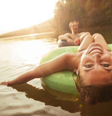 Paar schwimmt auf Reifen im See