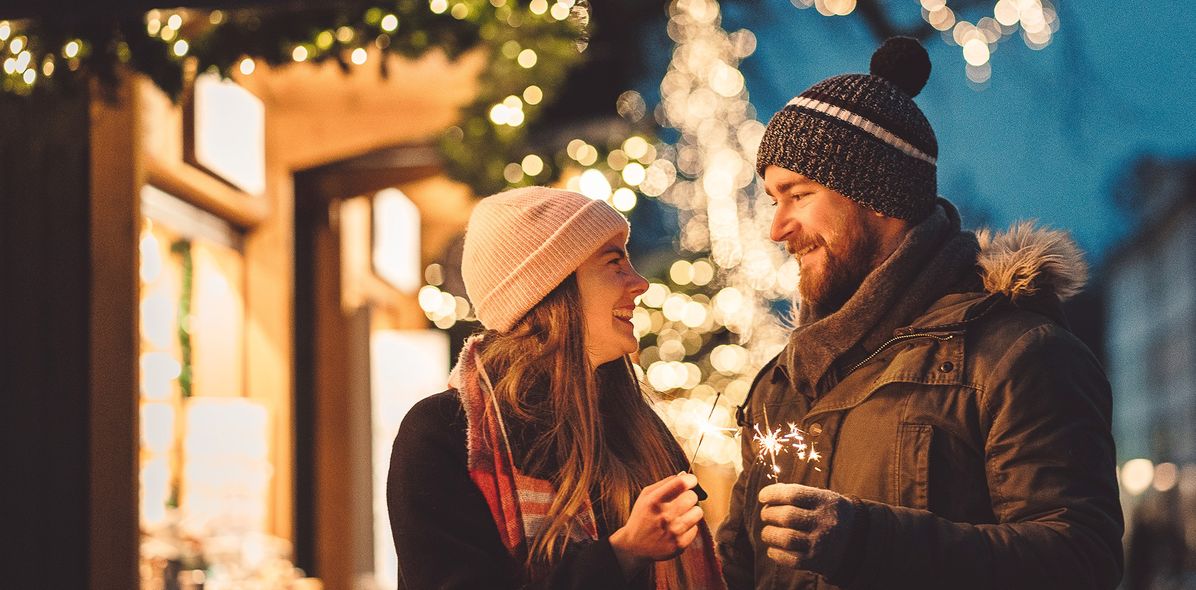 Paar mit Wunderkerzen am Weihnachtsmarkt
