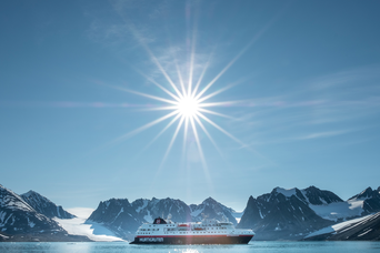 Kreuzfahrtschiff vor Eisbergen im Meer