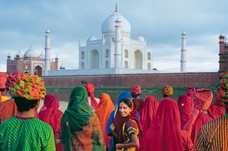 Besucher in bunten Saris vor dem Taj Mahal in Agra