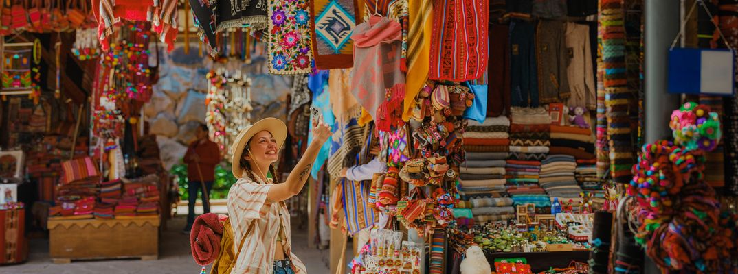 Frau an einem Stand auf dem Pisac Markt in Peru