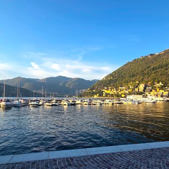 Comer See in Como in der Abenddämmerung mit Bergen und Booten, Italien