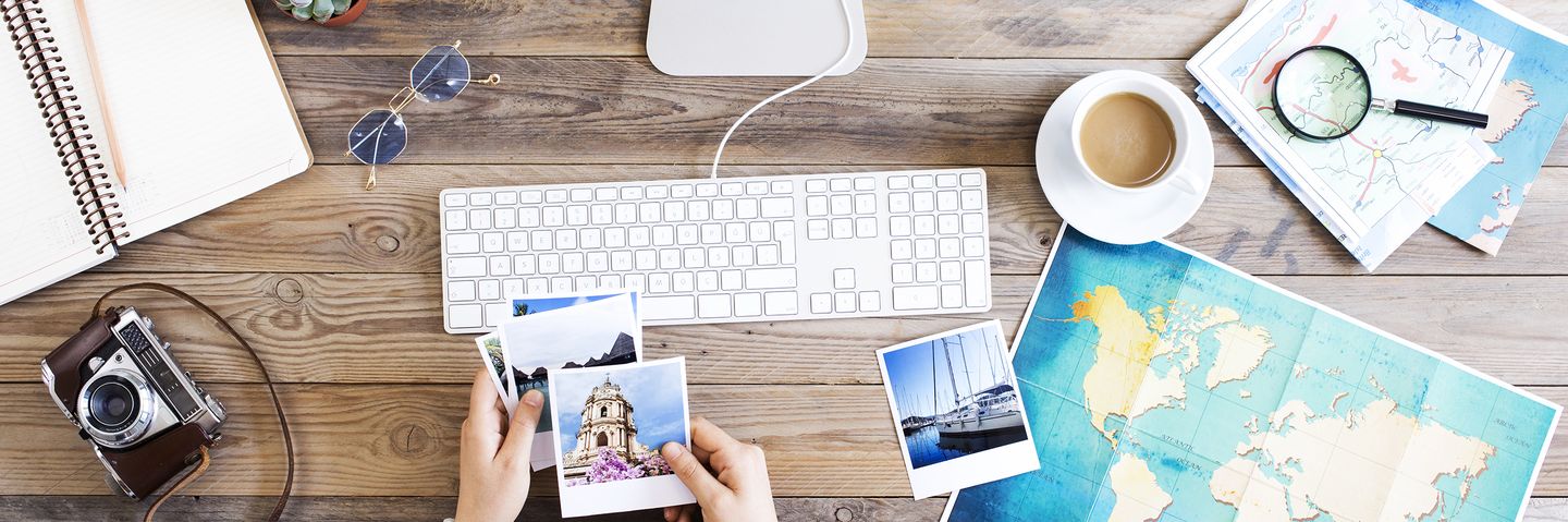 Frau sitzt am Computer und schaut sich Polaroid Photos an 