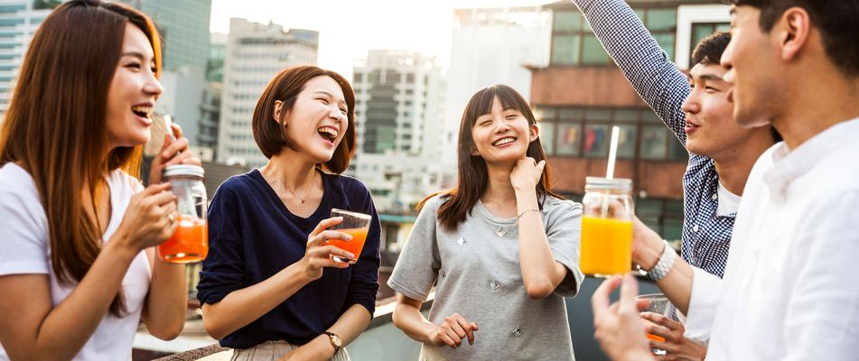 Eine Gruppe von Freunden in Seoul stoßen gemeinsam an und genießen Streetfood