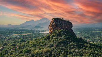 Der mächtige Löwenfelsen Sigiriya im goldenen Licht des Sonnenuntergangs, umgeben von tropischem Dschungel