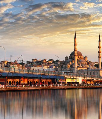 Moschee in Istanbul spiegelt sich im Wasser bei Sonnenuntergang mit Booten