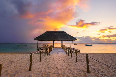 Holzsteg am Strand von Flic en Flac bei Sonnenuntergang, Mauritius
