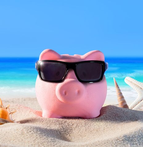 Rosa Sparschwein mit Sonnenbrille am Strand