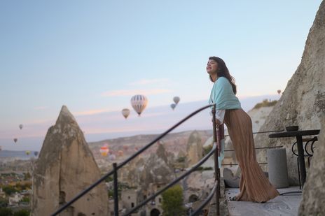 Frau genießt die Aussicht auf die Felslandschaft Kappadokiens bei Sonnenaufgang