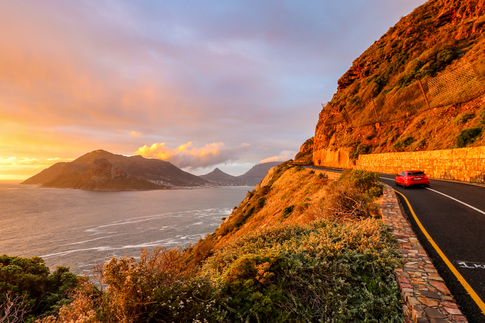 Ein Auto fährt auf der bekannten Straße Chapmans Peak Drive in Südafrika