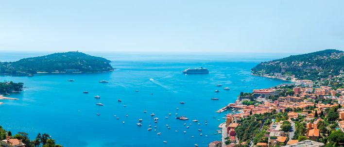 Blick auf die Küste von Nizza mit türkisblauem Meer und Booten