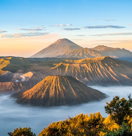 Blick auf den Vulkan Mount Bromo mit Nebelmeer und Kraterlandschaft bei Sonnenaufgang auf Java, Indonesien