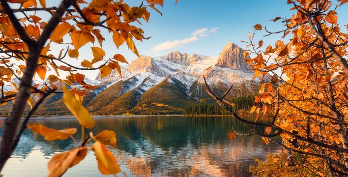 Herbstlandschaft in Alberta mit See, Bergen und goldgelben Bäumen