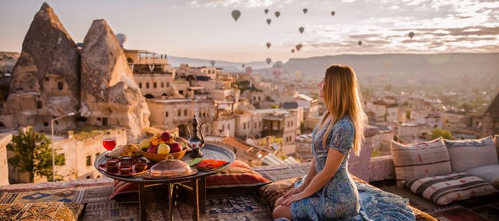 Frau beim orientalischen Frühstück mit Blick auf die Feenkamine von Kappadokien 