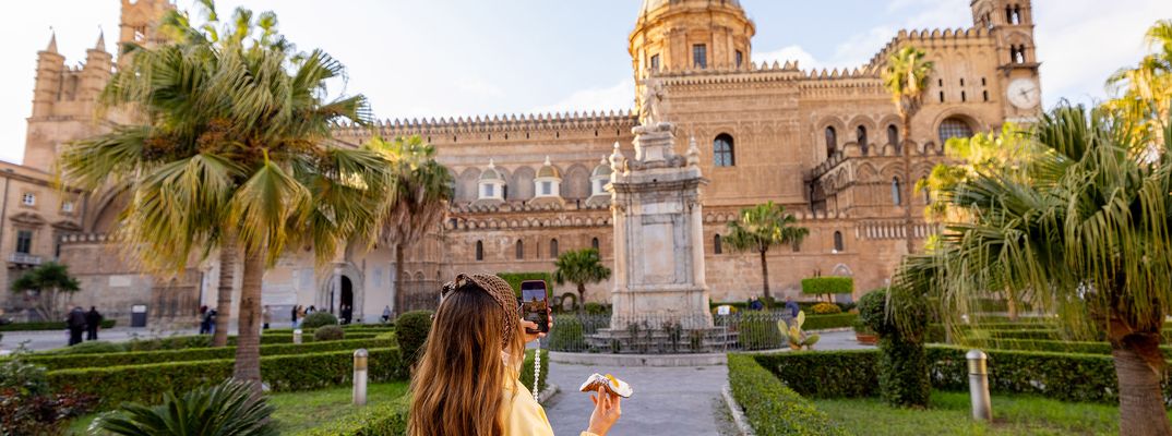 Frau vor der Kathedrale von Palermo mit Palmen und Platz