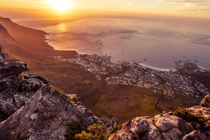 Kapstadt erstreckt sich bei Sonnenuntergang zwischen Tafelberg und Atlantikküste bis zum Horizont