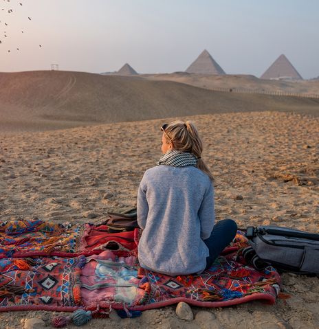 Frau blickt auf Pyramiden in Kairo