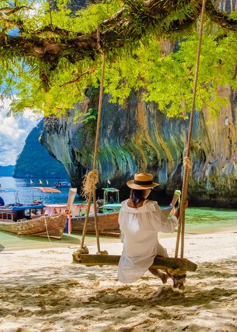 Frau auf Schaukel am Strand von Thailand