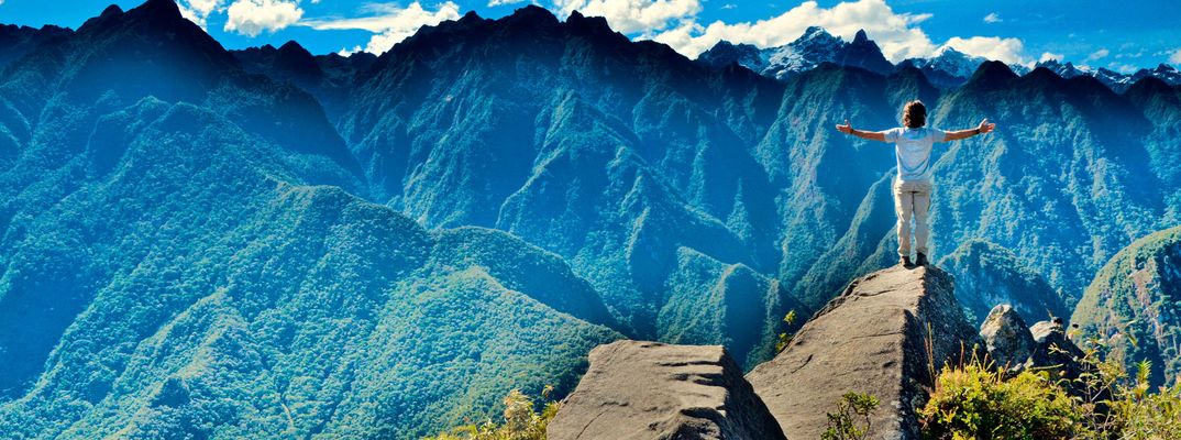 Eine Frau steht auf deinem Felsen und Blick in die peruanische Bergwelt