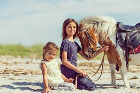 Kinder und Pferd am Strand von Sardinien