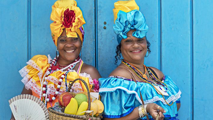 Zwei Frauen in traditioneller kubanischer Kleidung mit bunten Kleidern und Kopfschmuck