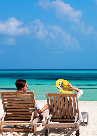 Paar in Liegestühlen am Meer