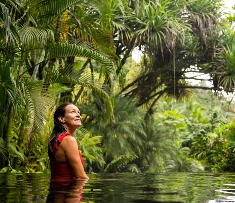 Frau in einem roten Badeanzug in einem Pool im Regenwald von Costa Rica