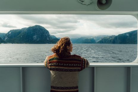 Frau schaut auf das Meer bei einer Kreuzfahrt
