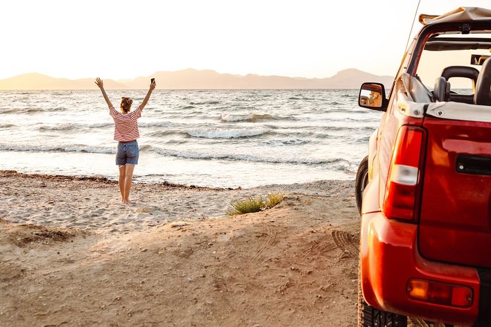 Frau mit Auto am Strand