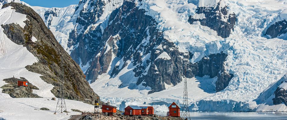 Häuser vor Eisbergen und Gletschern an der Paradise Bay in der Antarktis