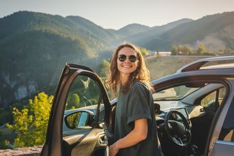 Frau vor Mietwagen in den Azoren in Portugal