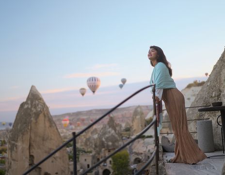Frau genießt die Aussicht auf die Felslandschaft Kappadokiens bei Sonnenaufgang