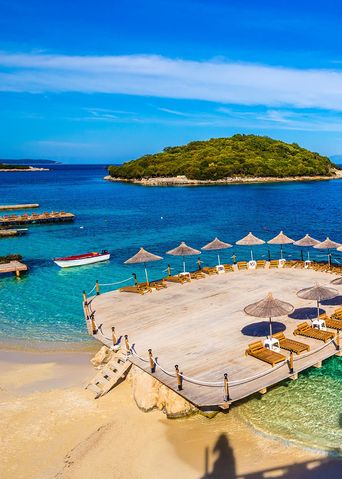 Der malerische Strand von Ksamil an der albanischen Riviera mit türkisfarbenem Wasser und kleinen Inseln