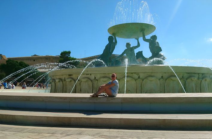 Mitarbeiterin Ulla vor einem Brunnen auf Malta