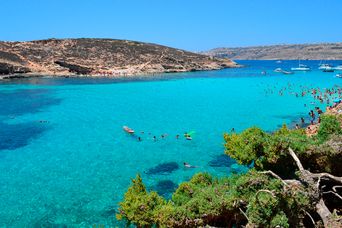 Menschen schwimmen türkisblauem Meer am Paradise Bay auf Malta