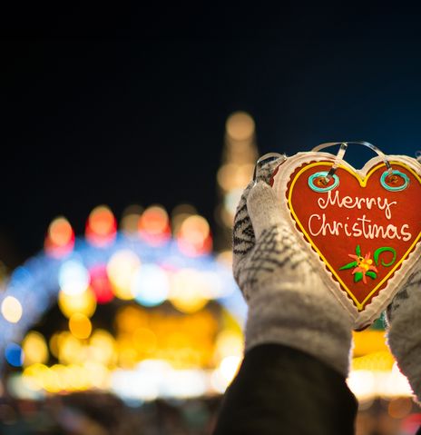 Hand mit Lebkuchenherz "Merry Christmas"