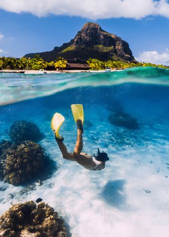 Frau taucht mit Schnorcheln und Flossen im Meer bei Mauritius