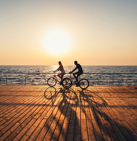 Paar fährt am Strand fahrrad