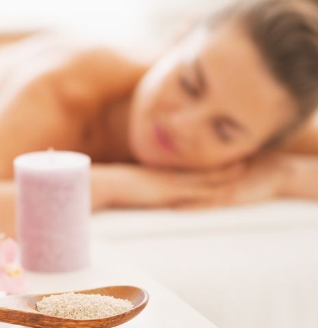 Frau bei Massage mit Kerzen