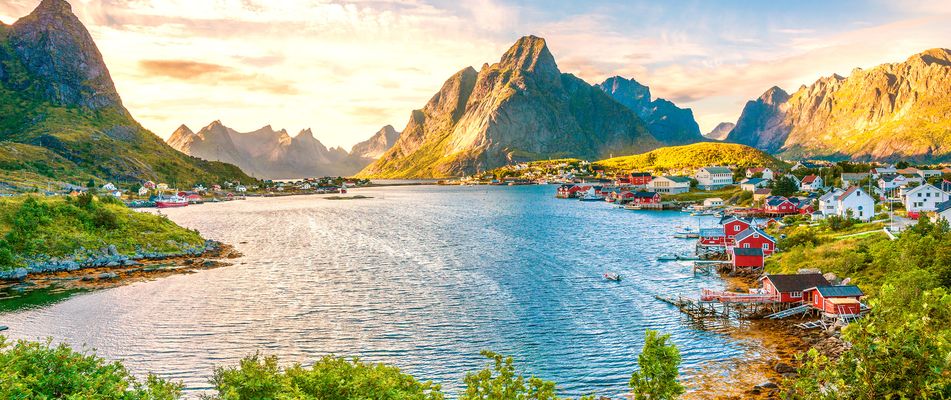 Küstenort Reine auf den Lofoten mit bunten Häusern und Bergen im Hintergrund