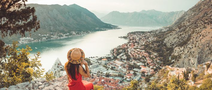 Frau blickt von einem Berg aus auf die Stadt Kotor