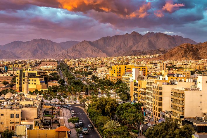 Stadtansicht von Aqaba mit Bergen und aufgewühlten Wolken im Hintergrund, Jordanien