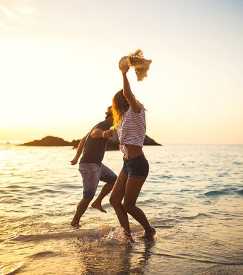Paar tanzt bei Sonnenuntergang am Strand