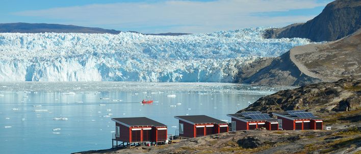 Ausblick auf die Gletscherfront nahe Ilulissat mit kleinen Häusern am Ufer