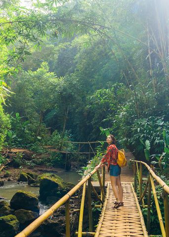 Frau auf einer Brücke am Wanagiri Wasserfall auf Bali