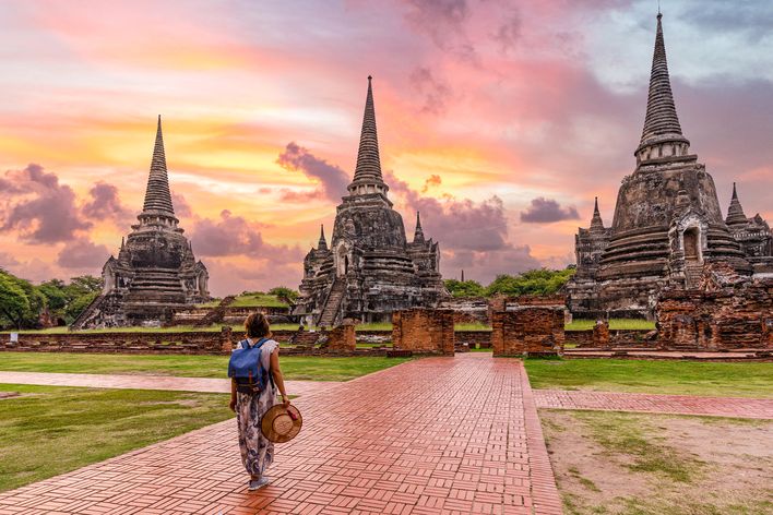 Eine Frau spaziert durch die Tempelanlage von Ayutthaya