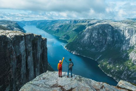 Paar beim wandern in Norwegen schauen auf prachtvolle Berg und Seekulisse