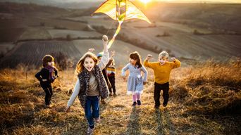 Kinder beim Drachensteigen im Herbst