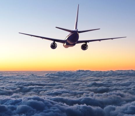 Flugzeug über Wolken bei Sonnenuntergang