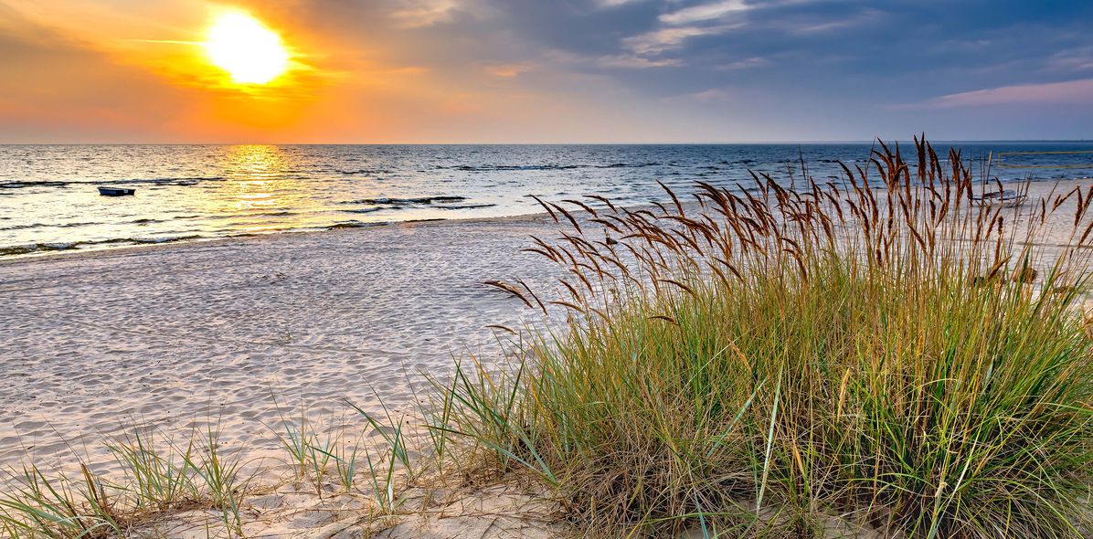 Sandstrand von Jurmala mit Dünengras und Blick auf die Ostsee bei Sonnenuntergang